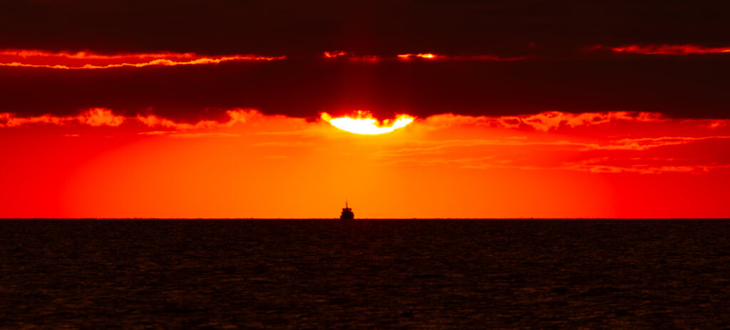 Fiery sunset over the Baltic Sea with a ship silhouette on the horizon, photographed from Paljassaare Peninsula, Estonia | Tulerõõmus päikeseloojang Läänemere kohal laeva siluetiga, pildistatud Paljassaare poolsaarelt, Eestist.