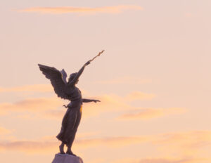The Russalka statue in Tallinn at sunset, with golden light illuminating the sculpture, set against the vibrant sky / Russalka kuju Tallinnas päikeseloojangul, kuldne valgus valgustab skulptuuri, taustal elav taevas