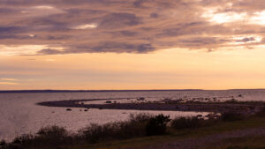 A stunning landscape shot of the sea with a strip of land curving into the water in an S-shape at sunset in Estonia / Pimestav maastikufoto merest, kus maasõõr, mis kulgeb vee sisse S-kujulise kurviga, jäädvustatud päikeseloojangul Eestis
