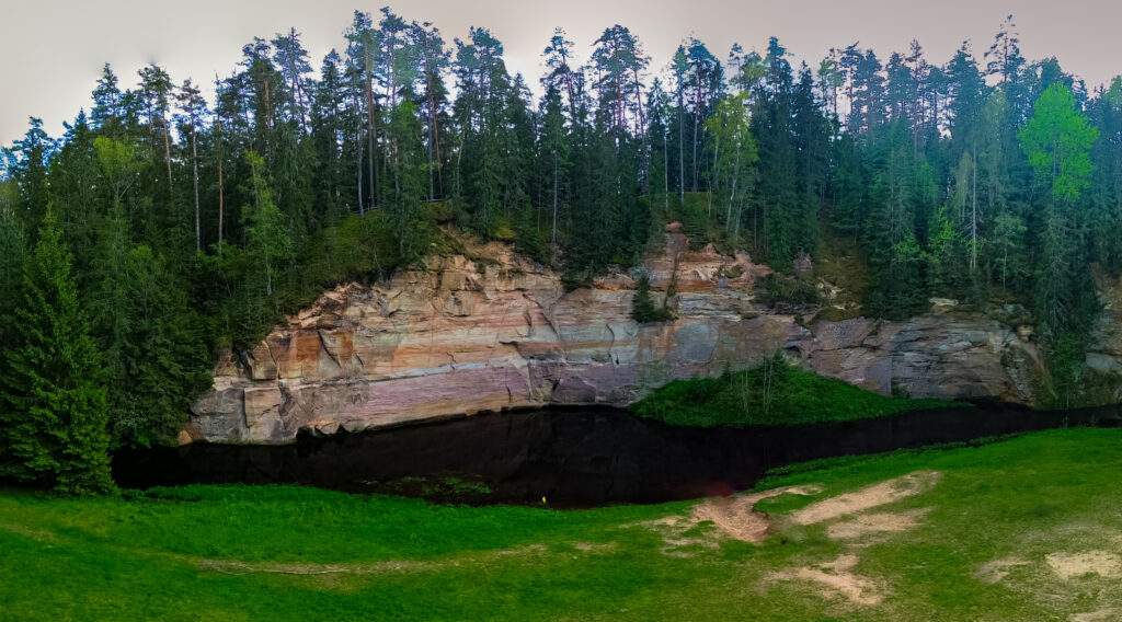 Sandstone cliffs of Suur and Väike Taevaskoda rising above the Ahja River in a lush Estonian forest