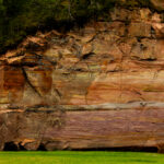 Sandstone cliffs of Suur and Väike Taevaskoda rising above the Ahja River in a lush Estonian forest