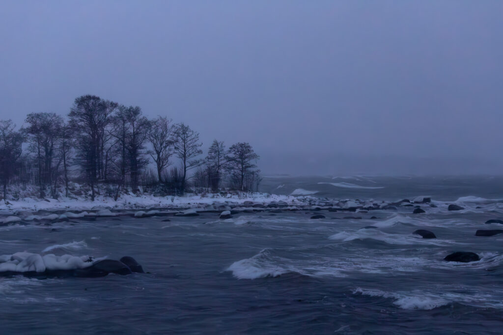 Snowy shoreline with turbulent waves