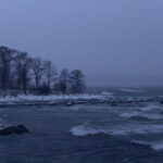 Snowy shoreline with turbulent waves
