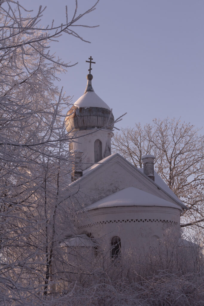 Snow-covered church with winter trees