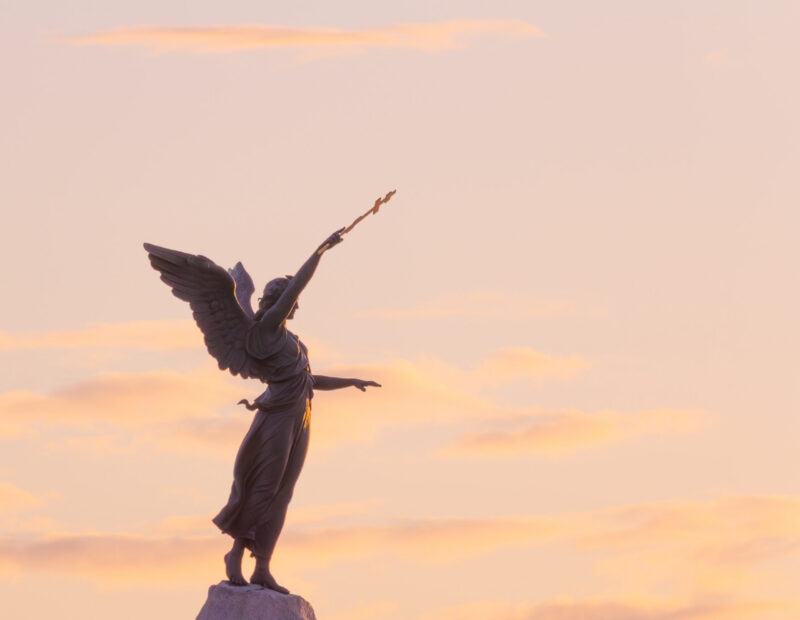 The Russalka statue in Tallinn at sunset, with golden light illuminating the sculpture, set against the vibrant sky / Russalka kuju Tallinnas päikeseloojangul, kuldne valgus valgustab skulptuuri, taustal elav taevas