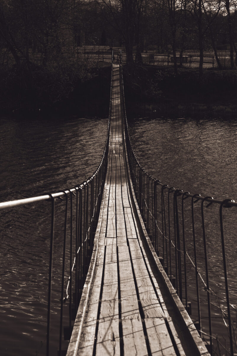 Jägala Rippsild bridge spanning over the river, with scenic views of the surrounding nature and Jägala Waterfall nearby / Jägala Rippsild, mis ulatub üle jõe, ümbritsevate loodusvaadete ja lähedal asuva Jägala juga taustal