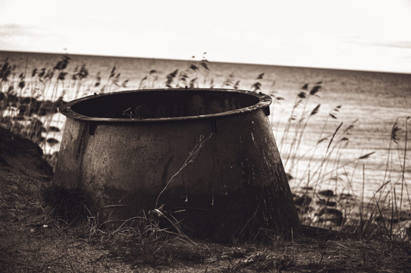 A derelict bunker near the sea in Estonia, surrounded by coastal vegetation and the vast seascape / Lagunenud punker Eesti rannikul, ümbritsetud rannataimestikust ja avarast meremaastikust