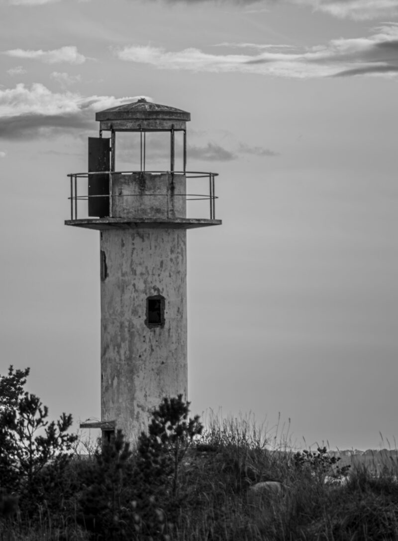 A derelict lighthouse standing near the Baltic Sea, weathered by time and surrounded by the rugged coastal landscape / Lagunenud tuletorn, mis seisab Läänemere ääres, aja poolt kulutatud ja ümbritsetud karmi rannamaastiku poolt
