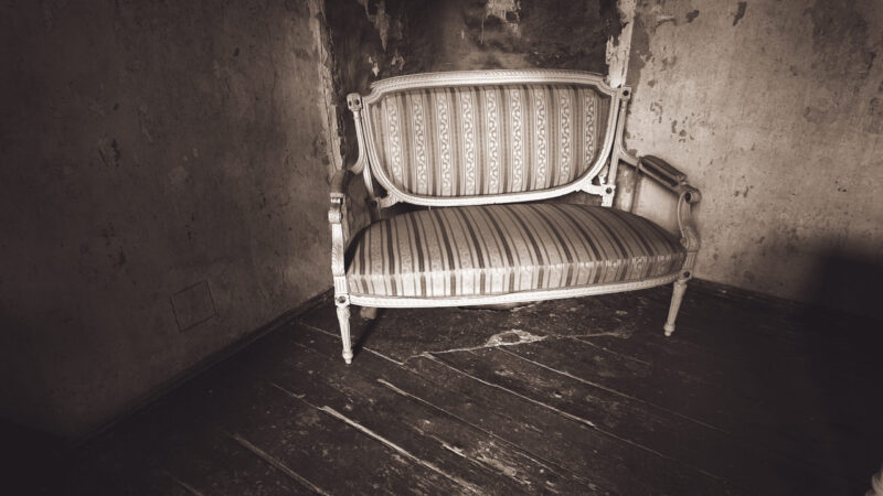 Vanaaegne diivan lagunevas vanas mõisas / Antique sofa in an old decaying mansion