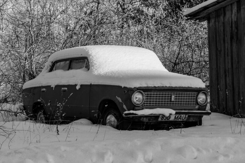 Abandoned car covered in snow