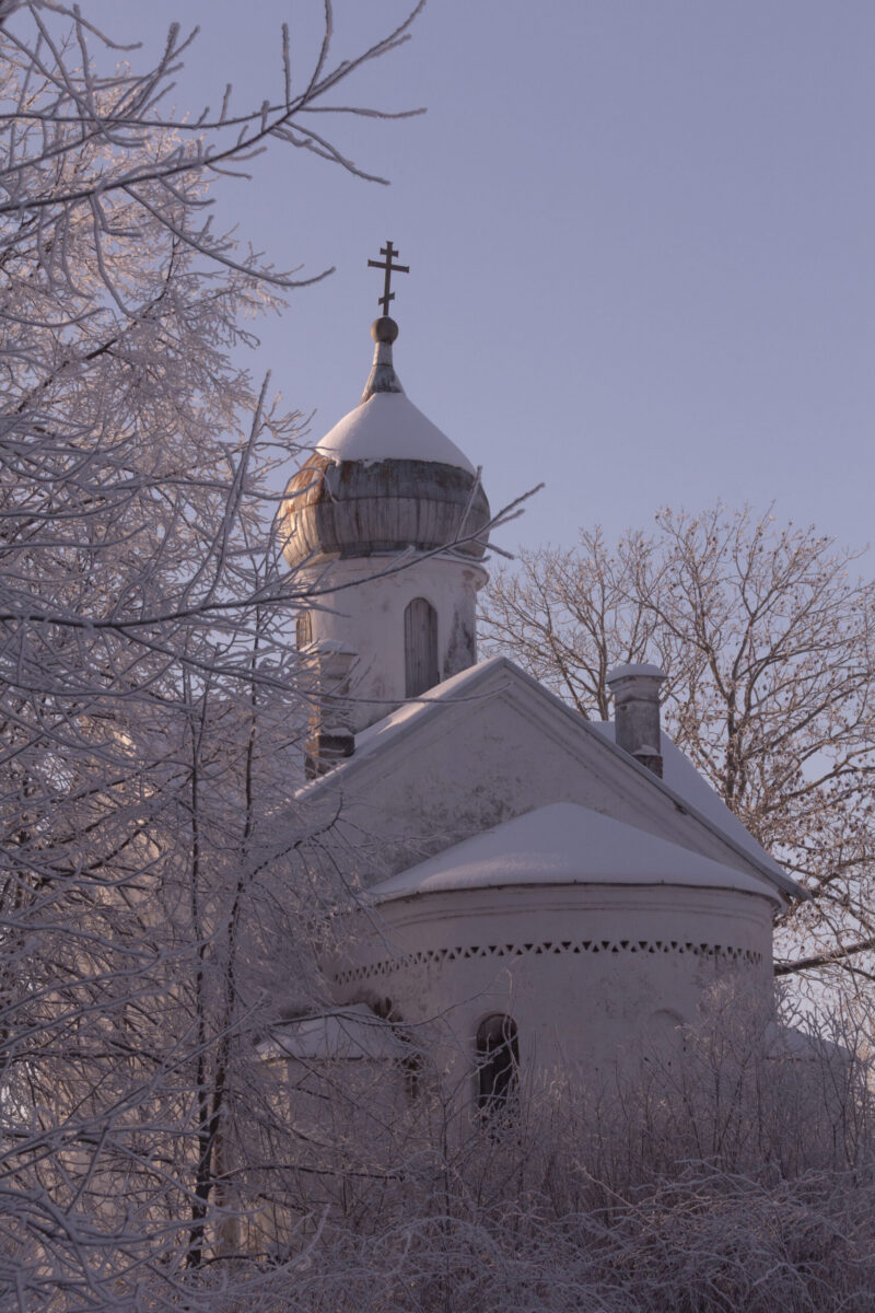 Snow-covered church with winter trees